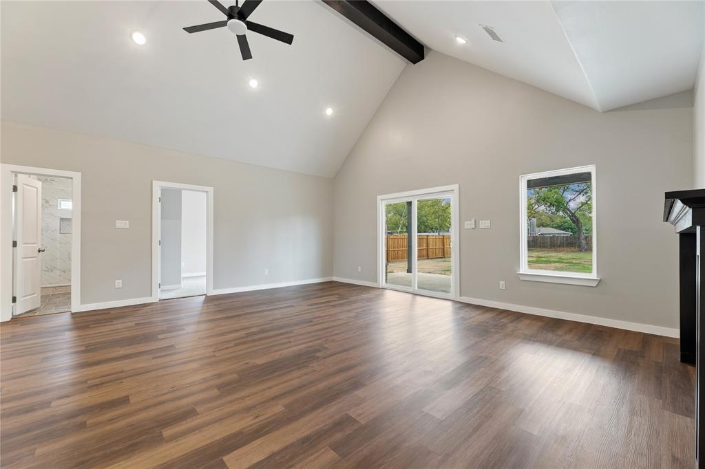 Vaulted ceilings featuring a dark wood-finish structural beam, wood-finish flooring, sliding glass door, and recessed lighting