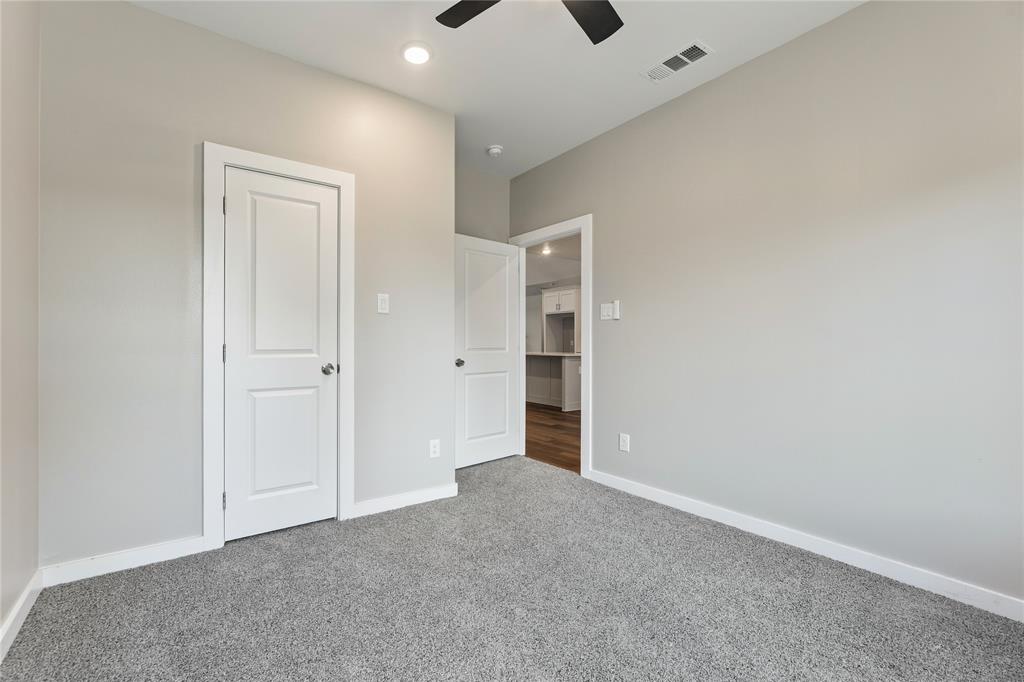 Neutral wall tones with grey carpeting, recessed lighting, and a multi-speed ceiling fan