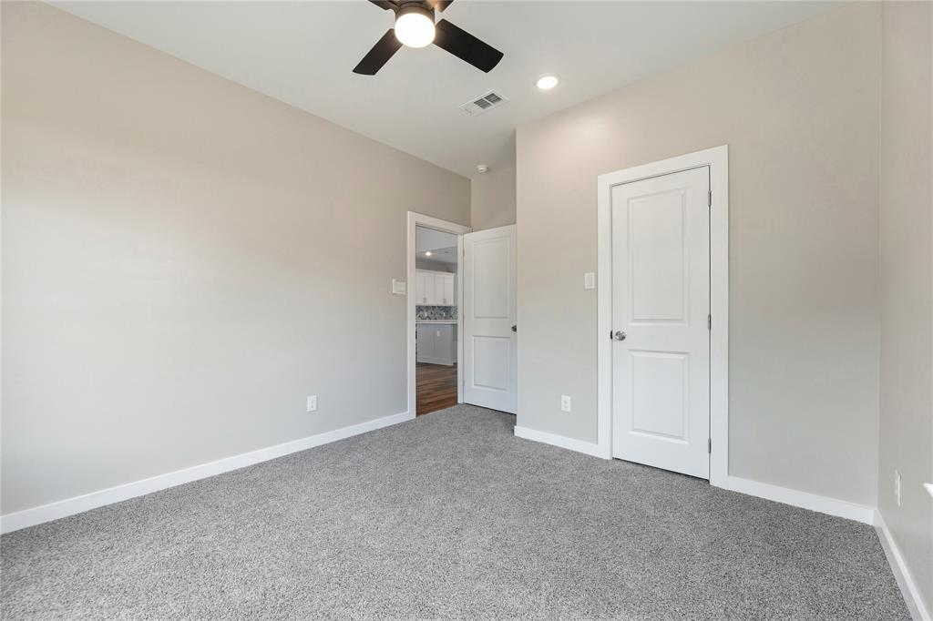 Neutral wall palette featuring plush carpeting, a multi-blade ceiling fan, and classic paneled interior doors