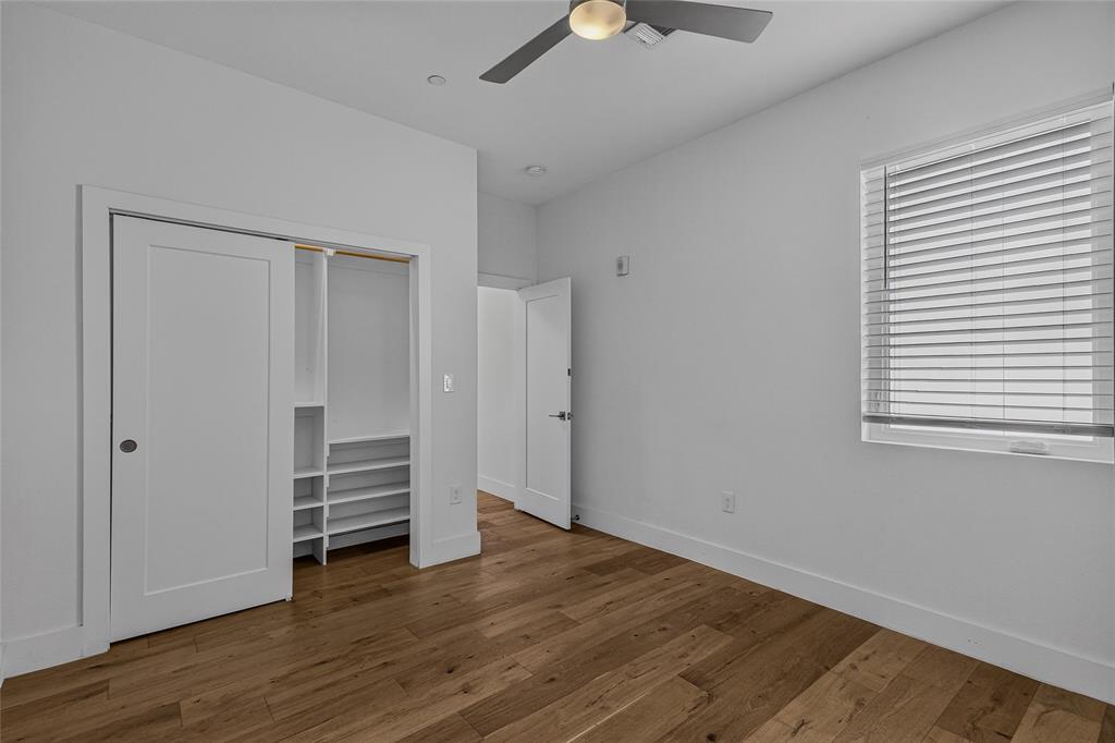Wood-finish flooring, recessed lighting, ceiling fan with integrated light, sliding closet door with built-in shelving, and window with horizontal blinds