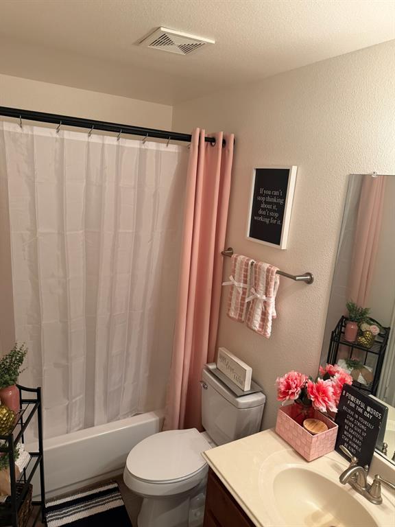 Full bathroom featuring a white porcelain tub, a wall-mounted brushed nickel towel bar, a vanity with an integrated basin, and a metal-framed mirror