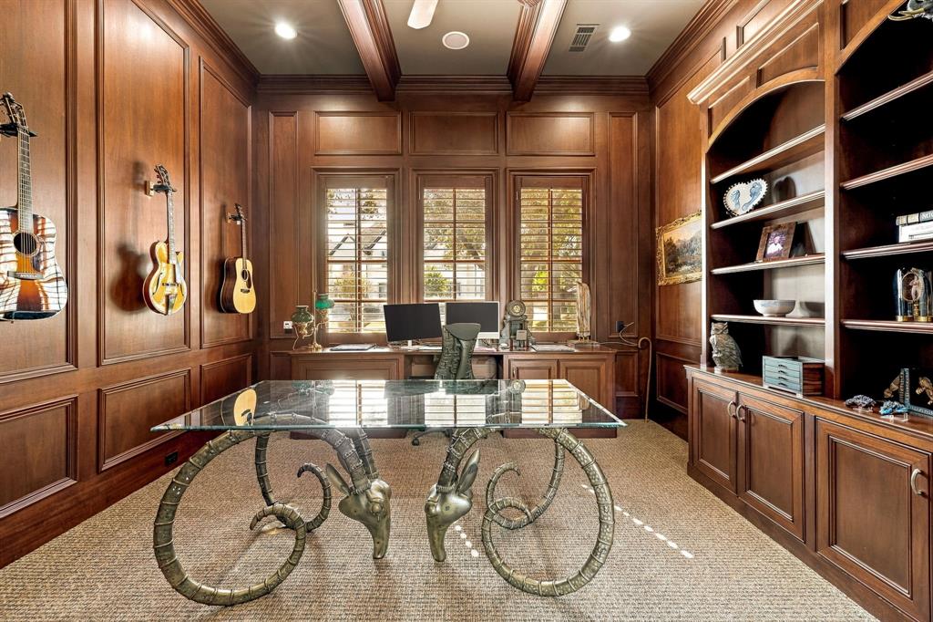 Paneled room featuring custom floor-to-ceiling wood cabinetry, recessed lighting, exposed ceiling beams, and wood-framed windows with integrated shutters