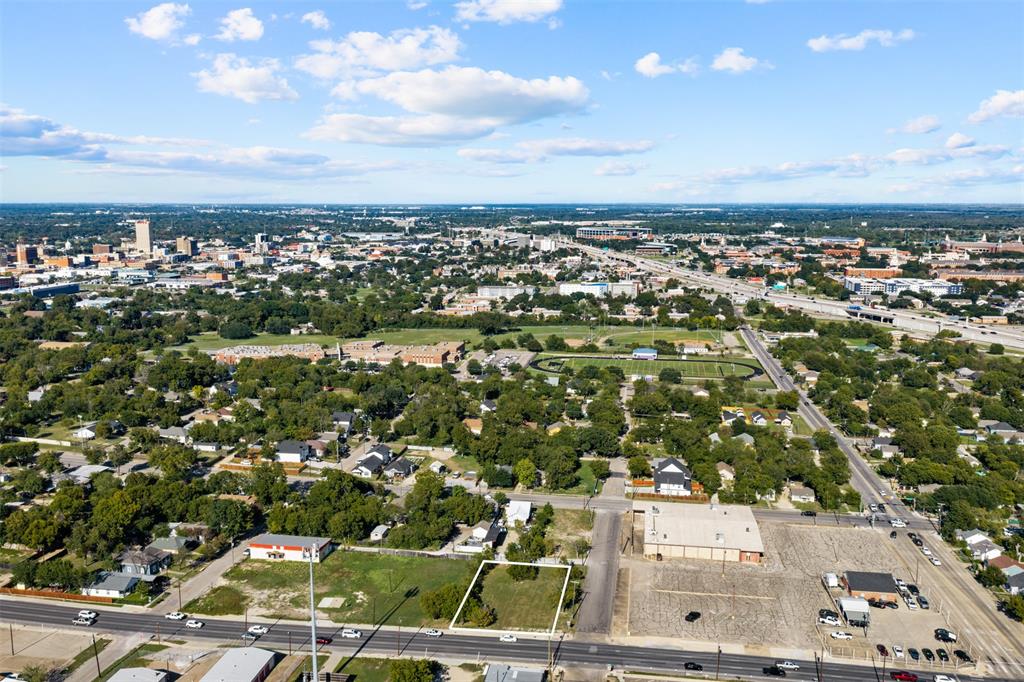 Cleared vacant lot situated along a paved thoroughfare with established tree coverage
