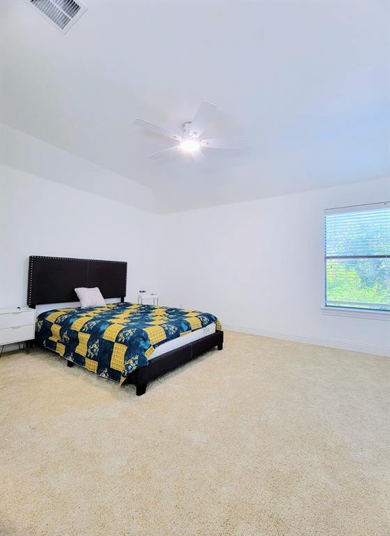 Room featuring a tray ceiling, wall-to-wall carpeting, neutral wall color, and a ceiling-mounted fan with an integrated light fixture Room featuring a tray ceiling, wall-to-wall carpeting, neutral wall color, and a ceiling-mounted fan with an integrated light fixture