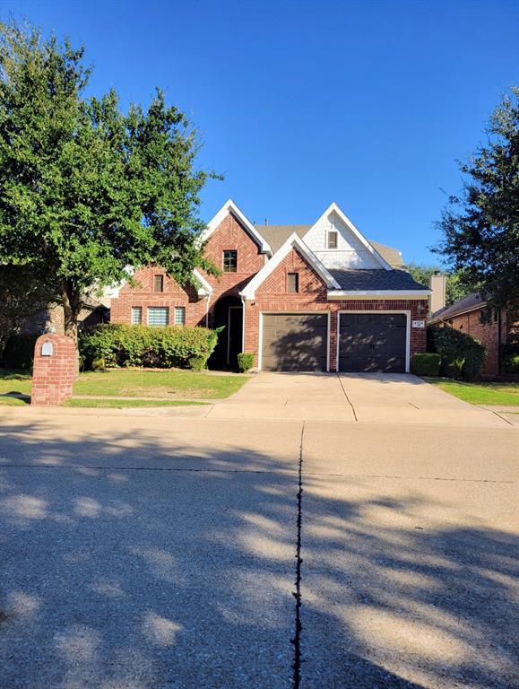 Brick facade exterior featuring a multi-gabled roofline, concrete driveway, and attached two-car garage Brick facade exterior featuring a multi-gabled roofline, concrete driveway, and attached two-car garage