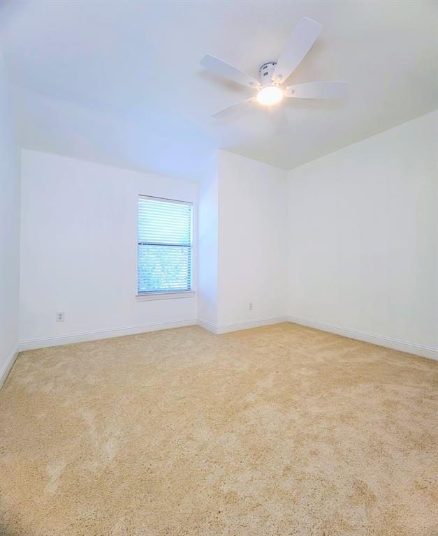 Neutral wall finishes, plush carpeting, single-pane window with horizontal blinds, and a white ceiling fan with integrated lighting Neutral wall finishes, plush carpeting, single-pane window with horizontal blinds, and a white ceiling fan with integrated lighting