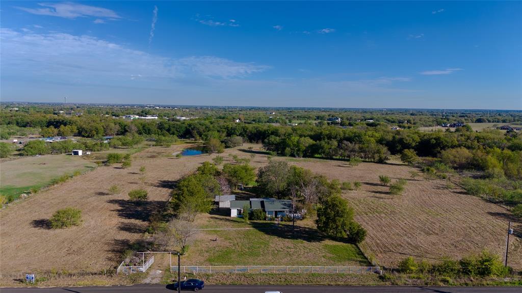 Expansive acreage featuring a single-story residence, mature tree clusters, and a private pond