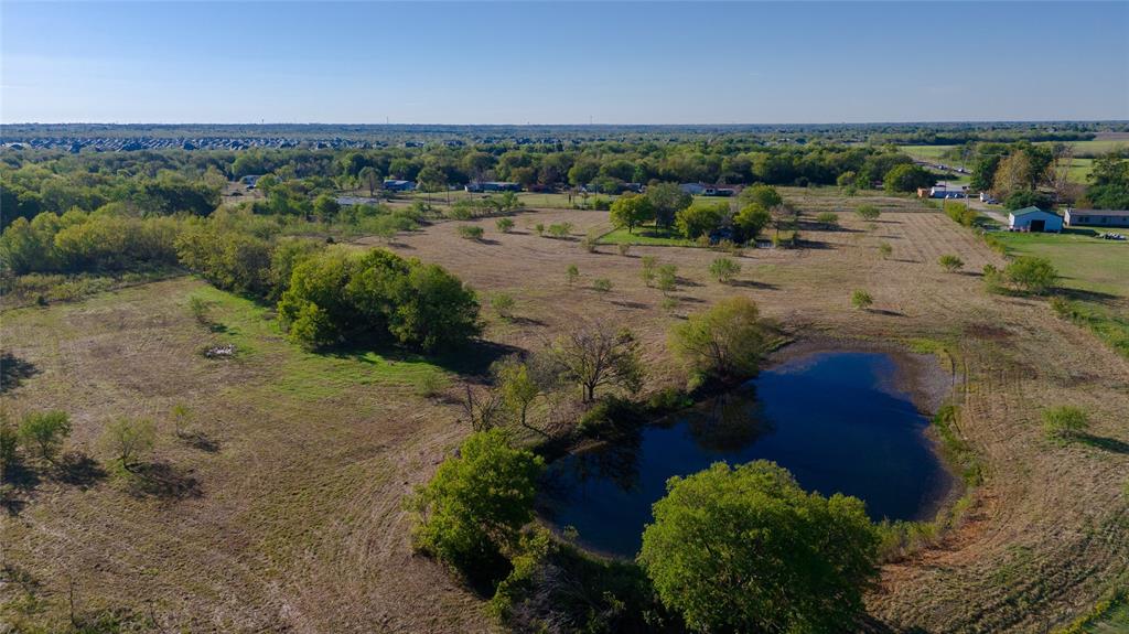 Expansive acreage featuring a private pond, mature trees, and open terrain
