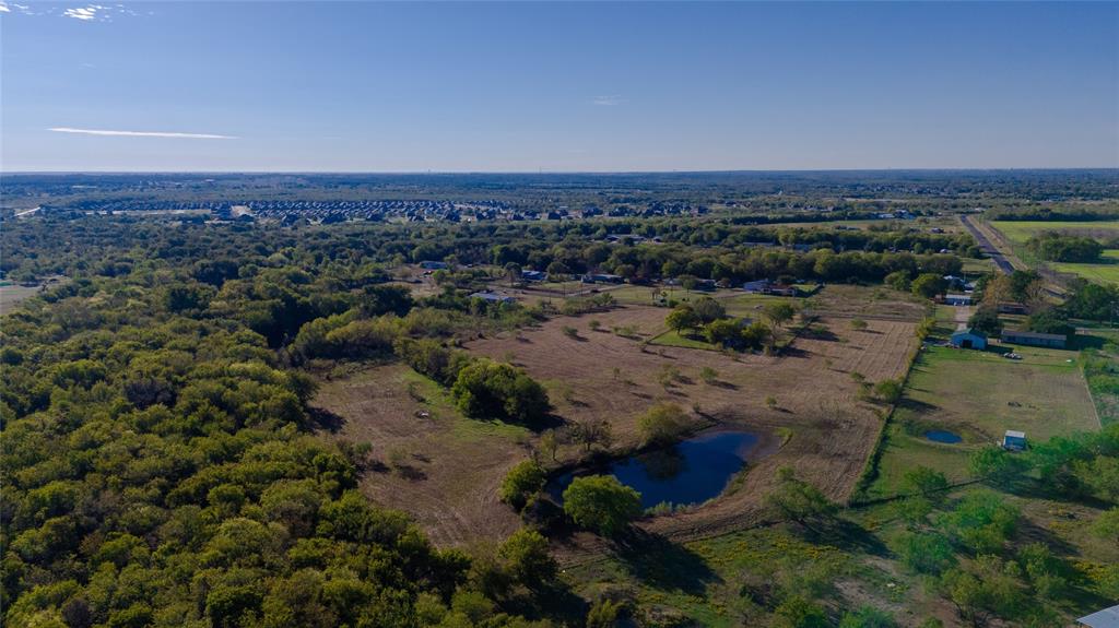 Expansive acreage featuring mature tree lines, open pastoral space, and a private pond