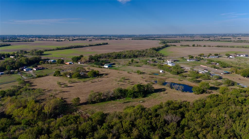 Expansive acreage featuring mature trees, open pasture, and a natural pond