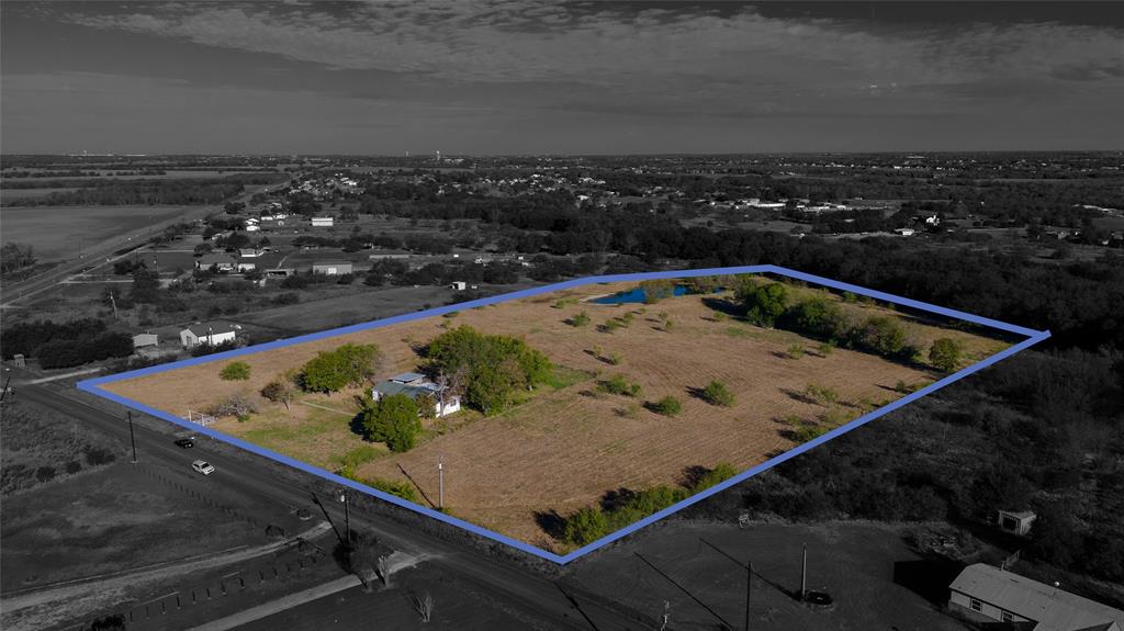 Expansive acreage featuring mature trees, a pond, and a detached structure