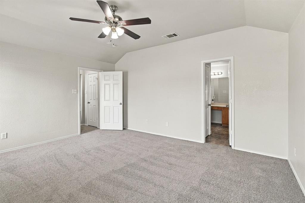 Vaulted ceilings, neutral carpeting, multi-light ceiling fan, and six-panel interior doors