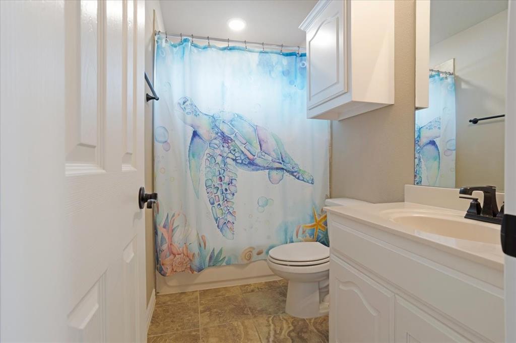 Bathroom featuring a white vanity with integrated sink, a wall-mounted medicine cabinet, and a commode