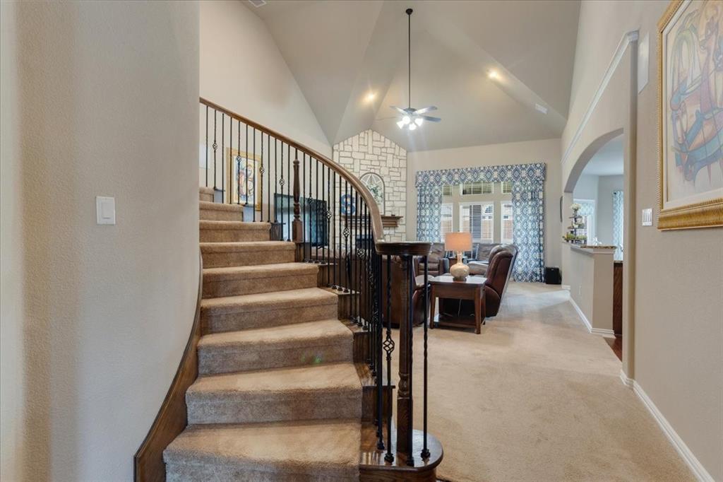Curved staircase with dark wood handrail and wrought iron spindles