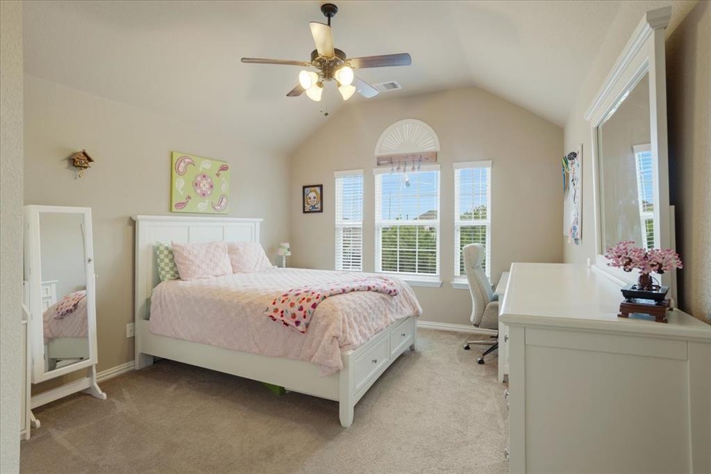 Bedroom featuring a vaulted ceiling with a ceiling fan, three windows with blinds, and neutral carpet flooring