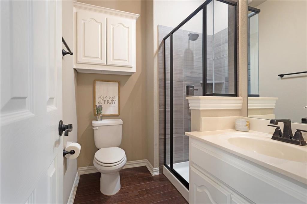 Bathroom featuring a walk-in shower with dark-framed glass enclosure, grey tile surround, and built-in niche