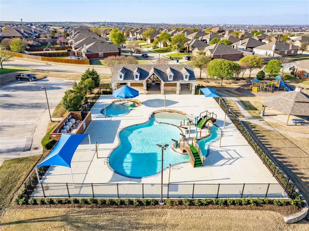Community pool complex featuring a large swimming pool with water features, a separate wading pool, and a bathhouse with stone and siding accents