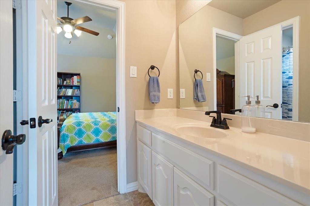 Bathroom vanity featuring a single undermount sink, a dark bronze faucet, and white cabinetry