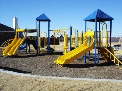 Outdoor play area featuring two slide structures with blue and yellow accents