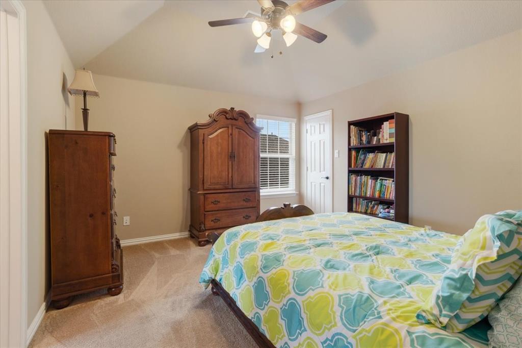 Carpeted room featuring a ceiling fan with integrated lighting, a double-hung window with blinds, and a white paneled door