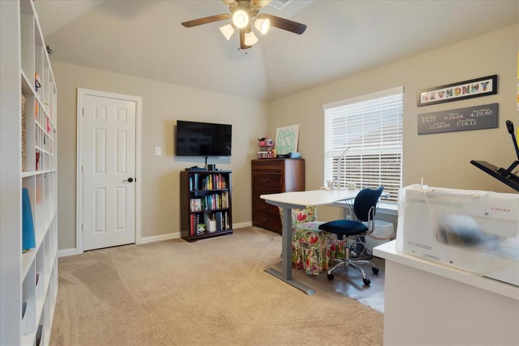 Carpeted room with a ceiling fan, a window with blinds, and white built-in shelving