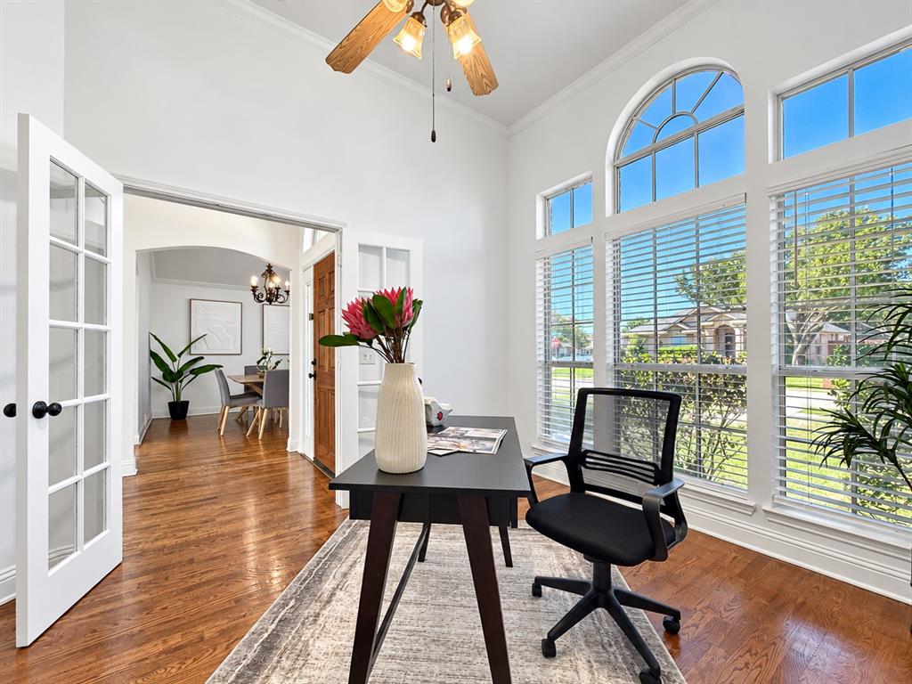 High ceilings, arch-top windows, wood-finish flooring, and French doors featuring glass panes