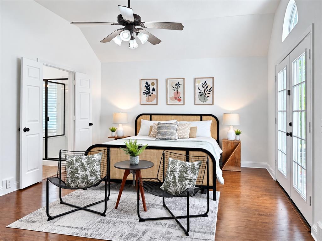 Vaulted ceiling, wood-finish flooring, French doors with glass panes, and a multi-light ceiling fan