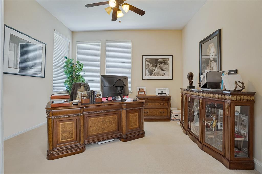 Interior featuring neutral wall paint, broadloom carpeting, three windows with horizontal blinds, and a ceiling-mounted light fixture with a fan