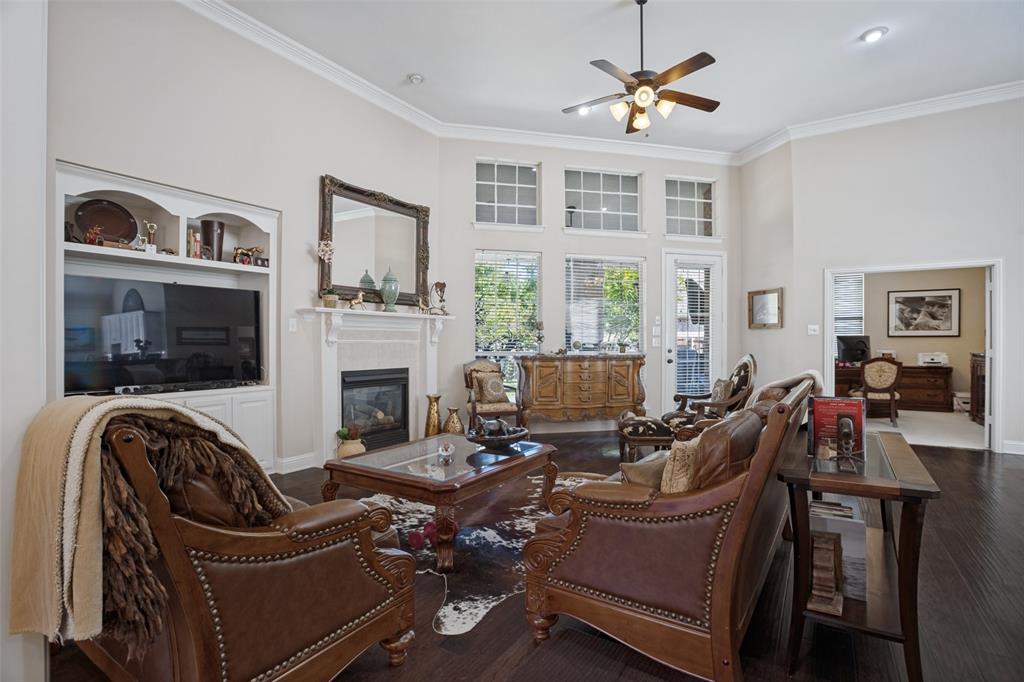 Vaulted ceilings, dark wood-finish flooring, built-in cabinetry, fireplace with a mantle, and grid-pattern windows
