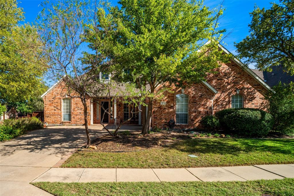 Traditional brick exterior featuring a multi-gabled roofline, arched entryway, and multi-pane windows