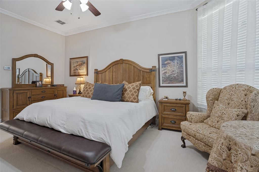 Neutral-toned interior space featuring high ceilings with crown molding and a central ceiling fan with integrated lighting