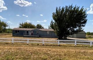 Single-level dwelling featuring a neutral-toned exterior, white perimeter fencing, and an attached secondary outbuilding Single-level dwelling featuring a neutral-toned exterior, white perimeter fencing, and an attached secondary outbuilding