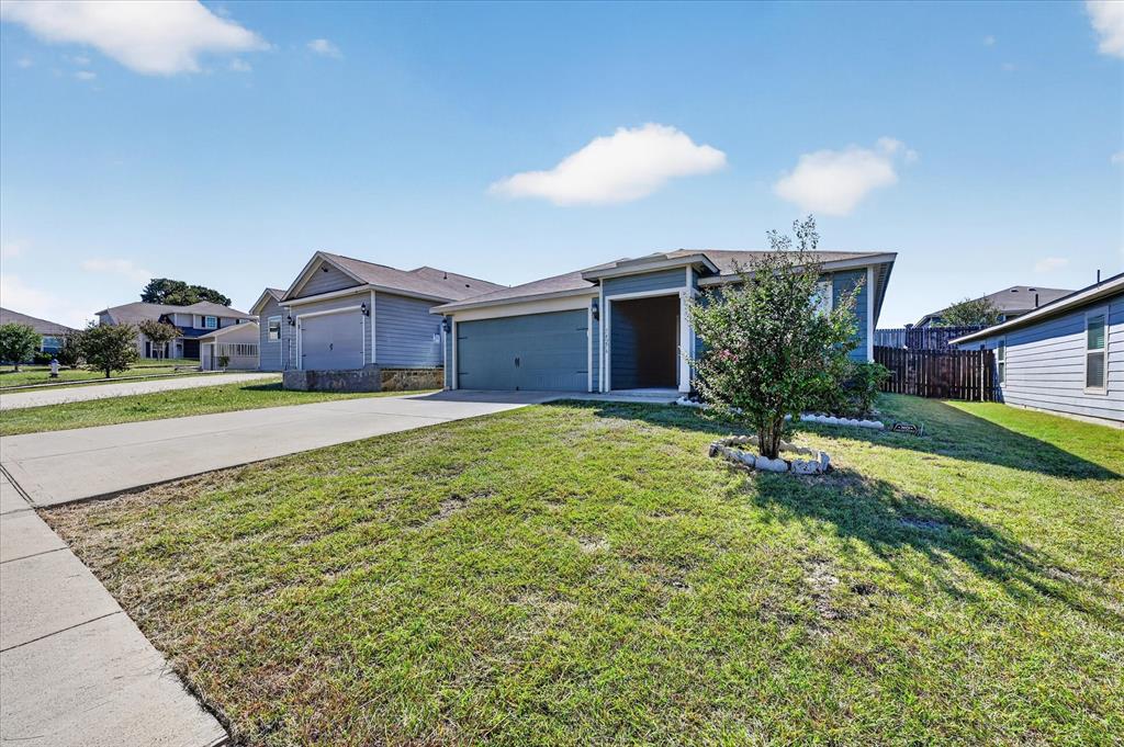 Single-story exterior featuring blue siding, a covered entryway, an attached two-car garage, and a concrete driveway Single-story exterior featuring blue siding, a covered entryway, an attached two-car garage, and a concrete driveway