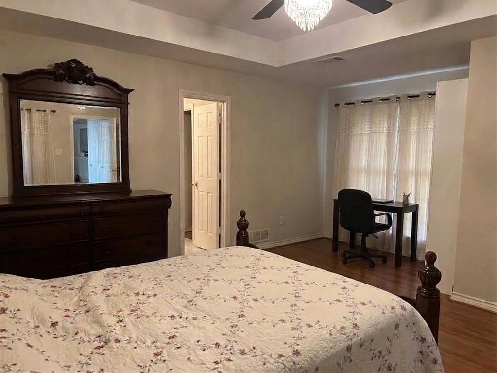 Tray ceiling, wood-finish flooring, and multi-light chandelier ceiling fan
