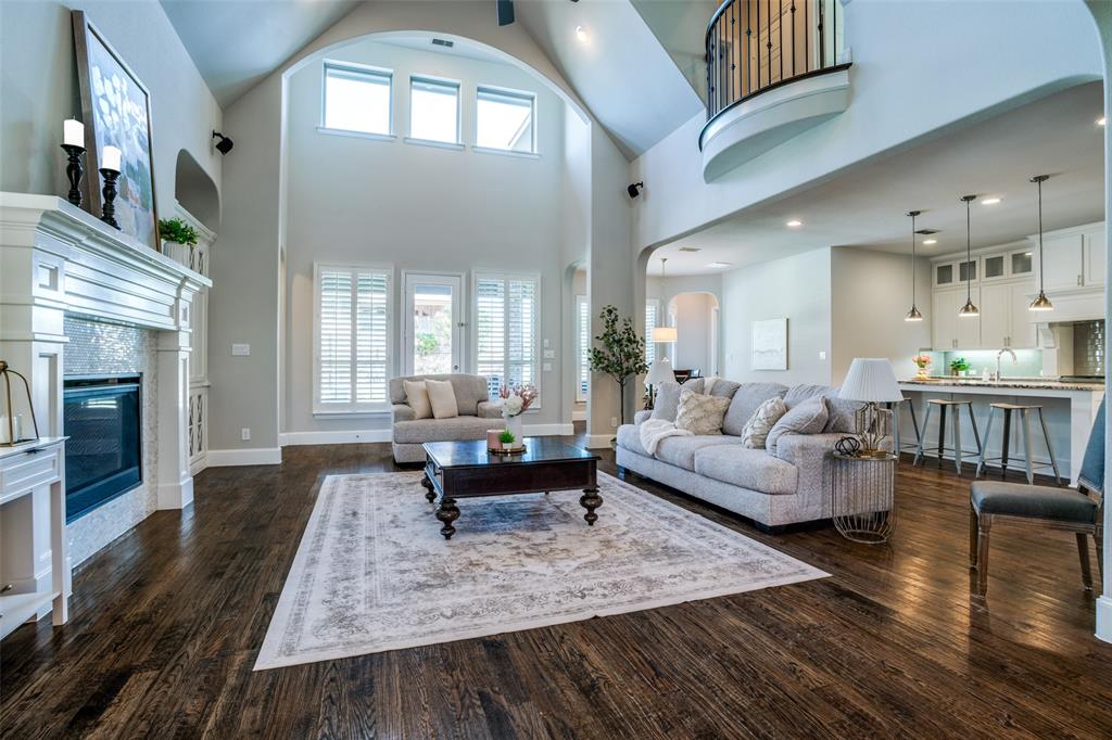 Living area featuring high vaulted 2 story ceiling, arched walkways, and a cozy fireplace