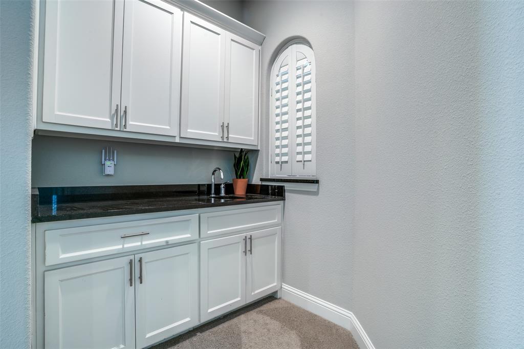 Upstairs wet bar in the game room featuring a sink and a pass thru window in the media room