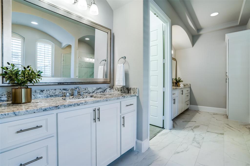 Bathroom featuring split vanities with lots of cabinets and framed mirrors