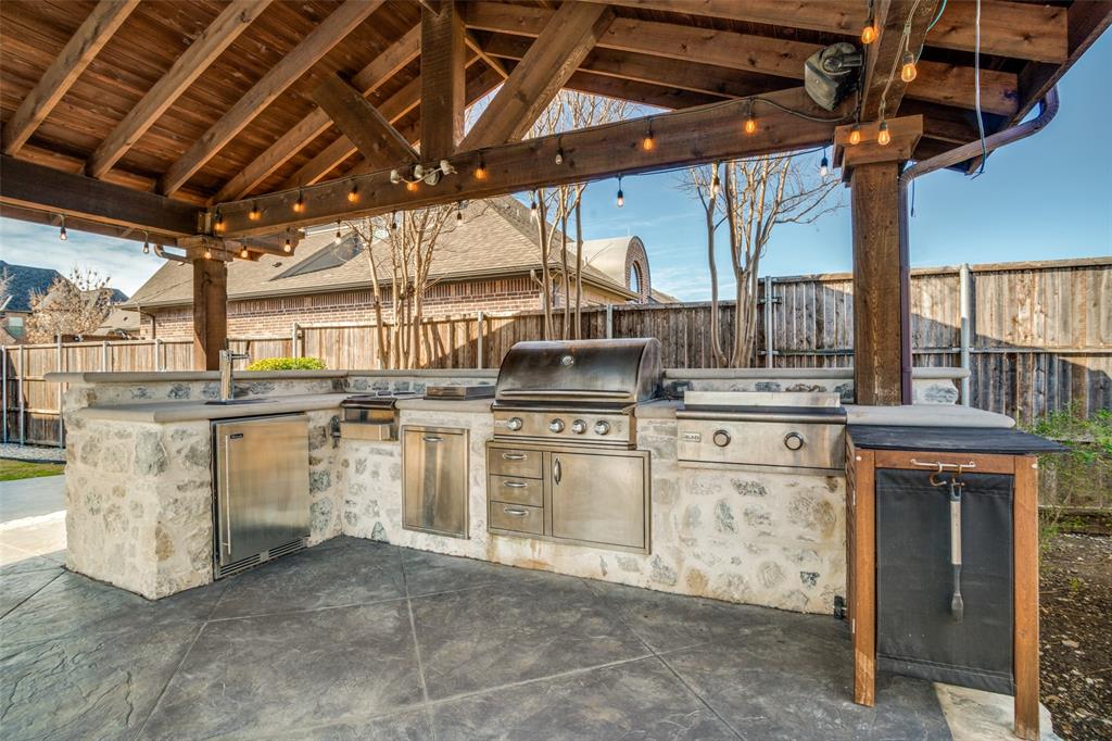 Huge  20 x 20 pergola type area with an outdoor kitchen with decorative concrete and stone accents.