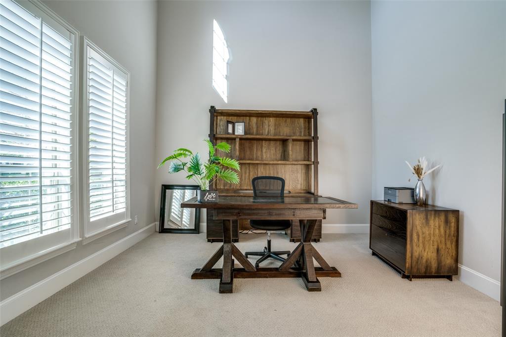 Office featuring soaring 2 story ceiling and double doors