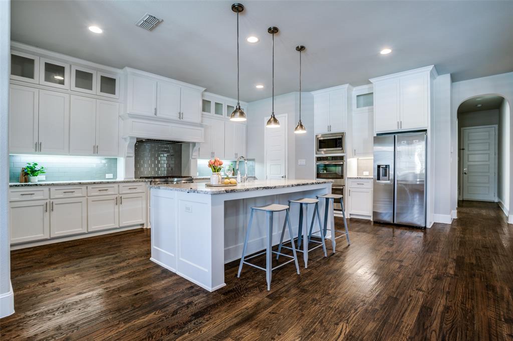 Kitchen featuring pendant lights over island and tall cabinets