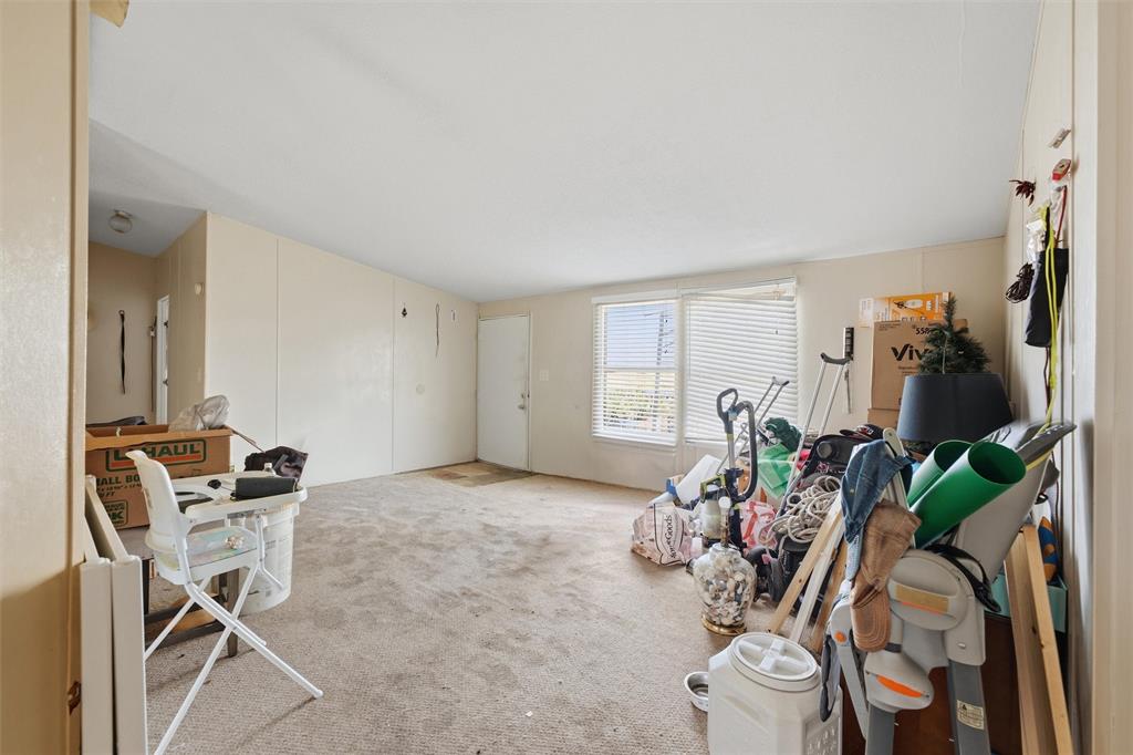 Interior area featuring neutral wall paneling, carpeting, and dual windows with horizontal blinds