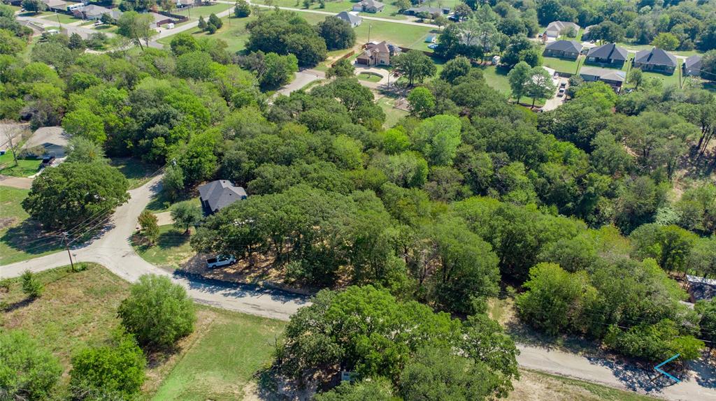 2 vacant lots are treed area to right of house on curve