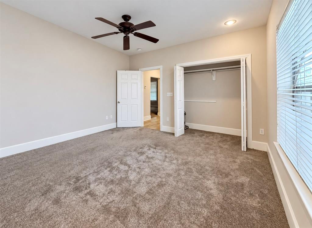 Neutral wall-to-wall carpeting, ceiling fan with light fixture, recessed lighting, and dual-panel closet with bi-fold doors