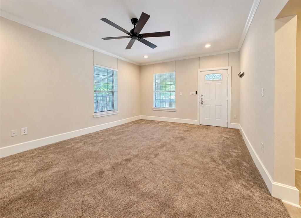 Room featuring neutral wall tones, plush wall-to-wall carpeting, recessed lighting, a matte black ceiling fan, and a paneled exterior door with a decorative glass insert
