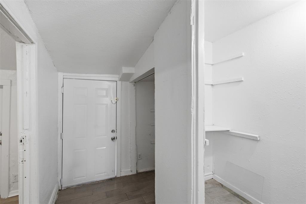 Six-panel interior door, wood-finish flooring, and built-in wall shelving Six-panel interior door, wood-finish flooring, and built-in wall shelving