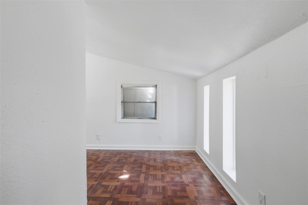 Parquet wood-finish flooring, vaulted ceiling, and multiple window placements