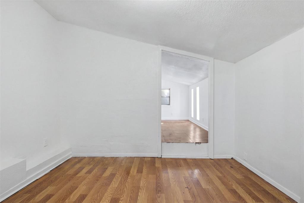Interior space featuring wood-finish flooring, white walls, and a recessed ceiling design with a wide open-entry portal