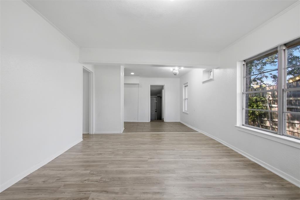 Interior space featuring wood-finish flooring, white walls, large multi-pane windows, and recessed lighting Interior space featuring wood-finish flooring, white walls, large multi-pane windows, and recessed lighting