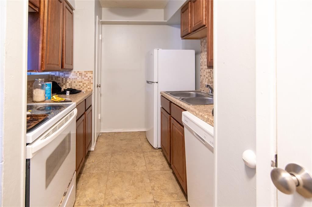 Kitchen featuring white appliances, tasteful backsplash, brown cabinetry, light countertops, and light tile patterned flooring