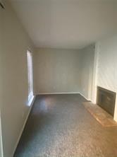 Unfurnished living room with a fireplace with raised hearth